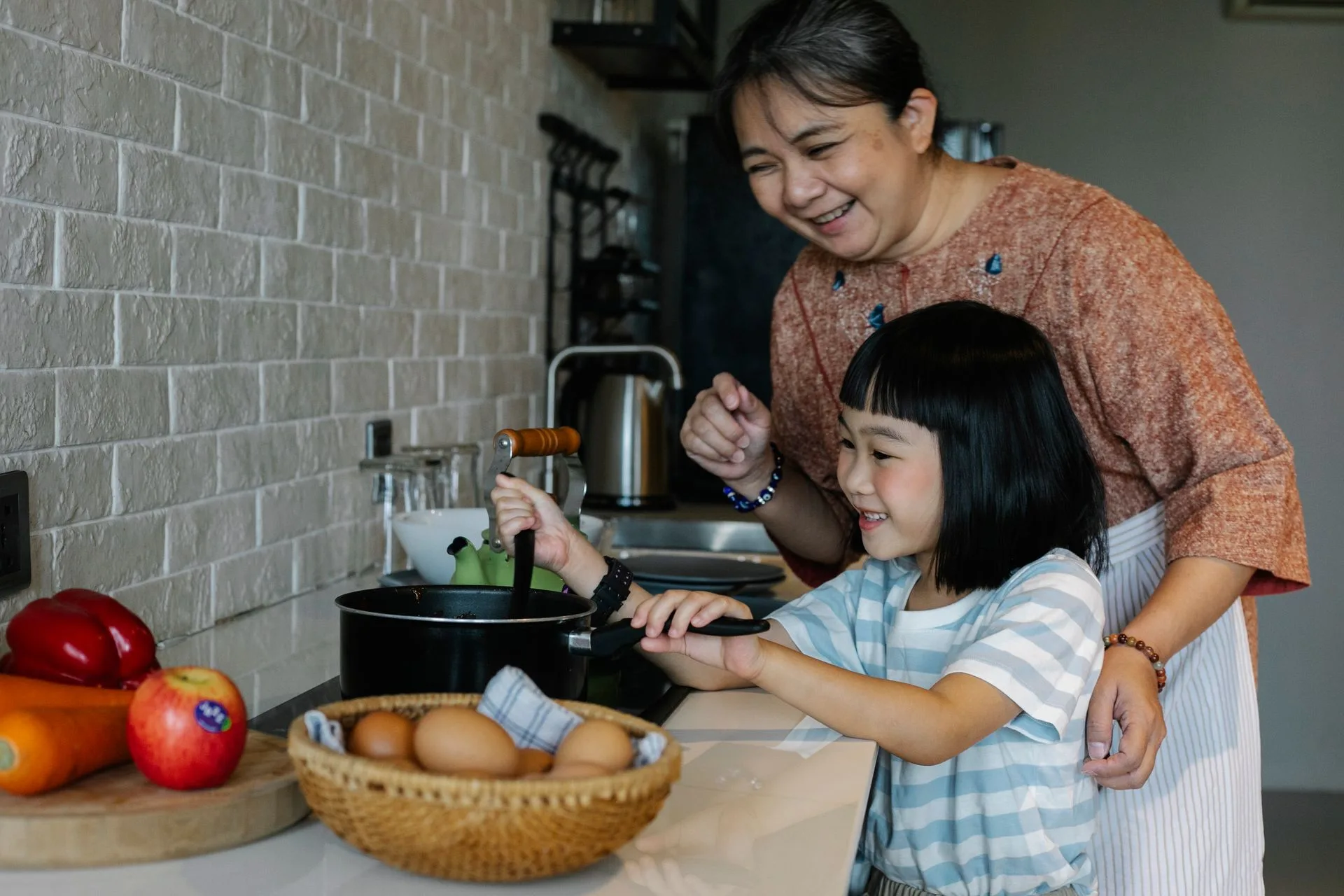 Bà và cháu cùng chuẩn bị bữa ăn trong căn bếp gia đình